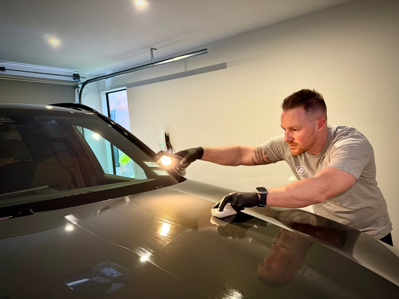 Ceramic coating being applied to the bonnet under inspection lighting